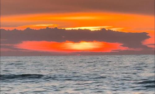 a sunset over the ocean with a cloud in the sky at Rezidenca Kalter Durres in Golem