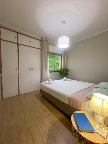 a bedroom with a bed and a table with a lamp at 2BR Estoril Apartment - Near Estoril Beach & Cascais - Sleeps 4 in Estoril