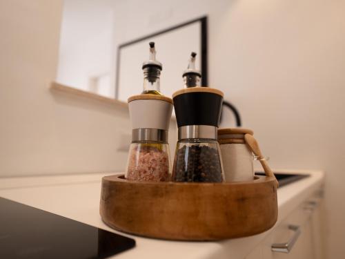 a counter with three bottles of spices in a wooden container at Maison Odile in Cefalù