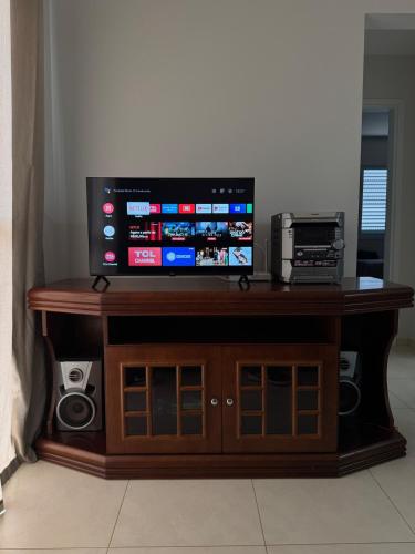 a flat screen tv sitting on top of a wooden cabinet at Apartamento Melbela IV AP 41 in Espirito Santo Do Pinhal