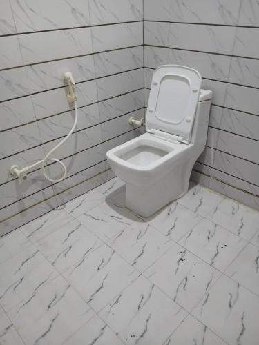 a bathroom with a white toilet in a wall at La vie Livings Only For Female in Noida