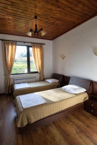 a bedroom with three beds and a window at Лунен залив in Dospat