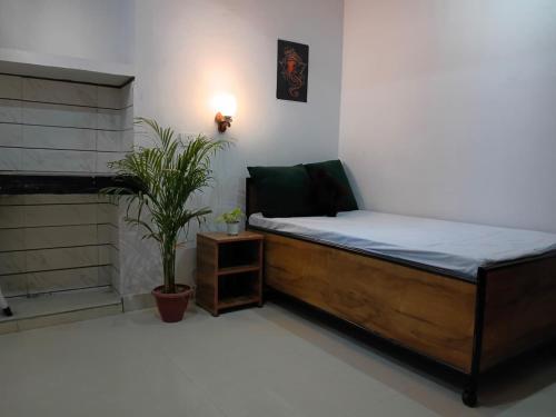 a bedroom with a bed and a potted plant at La vie Livings Only For Female in Noida