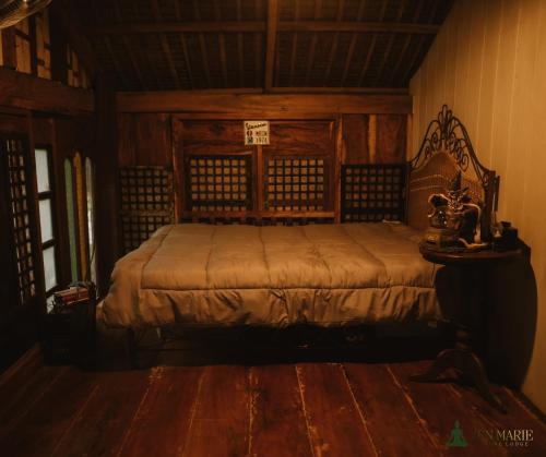 a bedroom with a bed with a wooden head board at Zen Marie Tanay in Sampong