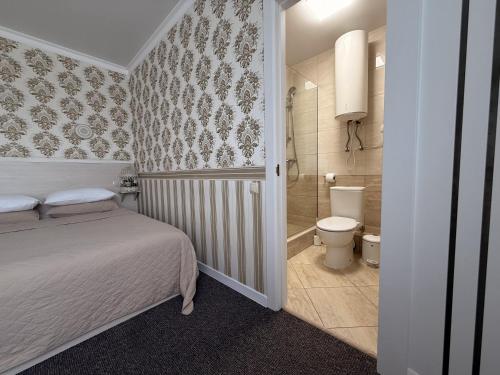 a bedroom with a bed and a bathroom with a toilet at Готель Лаванда in Khmelnytskyi