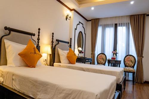 a hotel room with two beds and a mirror at Maison Julie Duong in Hanoi