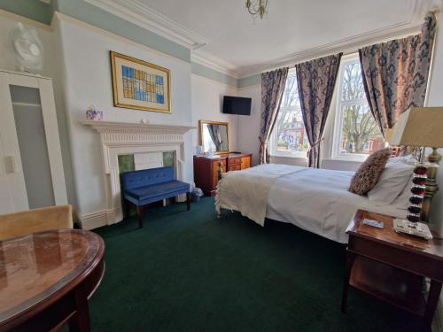 a bedroom with a bed and a chair and a fireplace at Shearwater in Bridlington