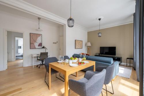 a living room with a table and blue chairs at Apartment with Private Balcony in central Copenhagen City in Copenhagen