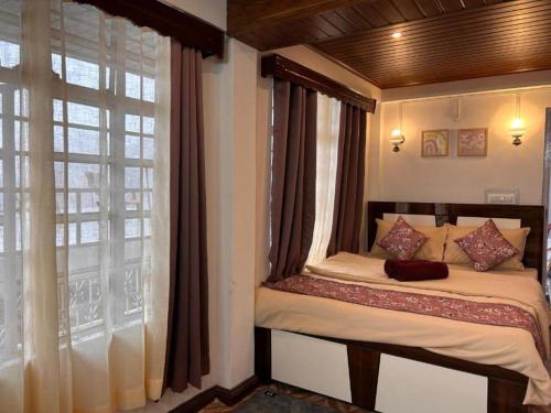 a small bed in a room with a window at The Manzil Boho in Darjeeling