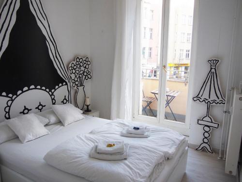 a bedroom with a white bed with two towels on it at Box61 Art Concept Flat in Berlin
