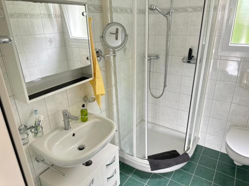 a white bathroom with a sink and a shower at HOLIDAY Residence Sette Nani in San Nazzaro