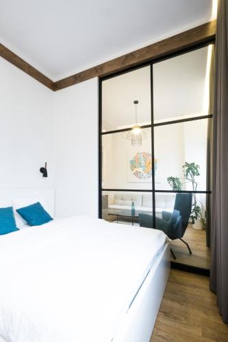 ein Schlafzimmer mit einem großen Fenster und einem Stuhl in der Unterkunft Apartment on Dauksos 18 in Kaunas