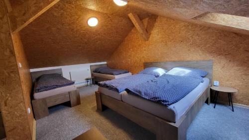 a bedroom with two beds in a attic at Apartmán u kolejí A in Kašnice