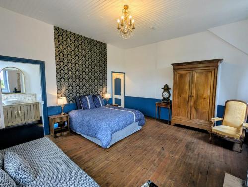 a bedroom with a blue bed and a chair at Domaine de la Dordrona in Brantome en Perigord