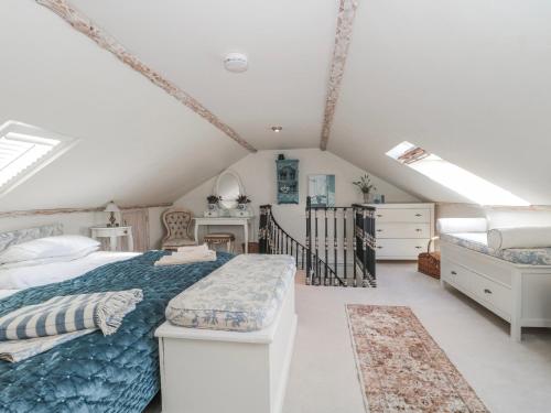 a bedroom with a large bed with a blue comforter at 7 The Cedars in Wotton-under-Edge