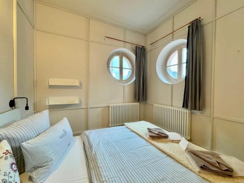 a bedroom with a bed and two mirrors at Schloss Prossen in Bad Schandau