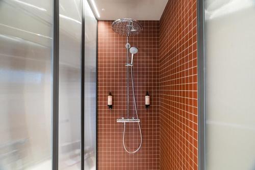 a bathroom with a shower in a tiled wall at mk2 Hotel Paradiso Nation in Paris