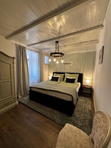 a bedroom with a large bed and a chandelier at Gémes Vendégház in Vitnyéd