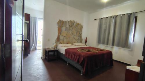 a bedroom with a bed with a red blanket at Country Club Pititinga in Pititinga