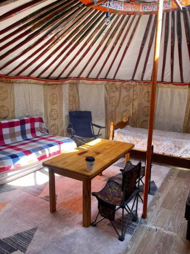a room with a table and a bed in a yurt at Yurt near terelj in Nalayh