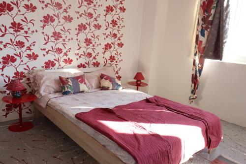 a bedroom with a bed with red floral wallpaper at Holiday Home Desire in Kras