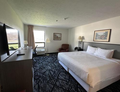 a hotel room with a bed and a television at Ramada by Wyndham Strasburg Dover in Strasburg