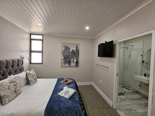 ein Schlafzimmer mit einem großen Bett und einer Dusche in der Unterkunft Clanwilliam Accommodation in Clanwilliam