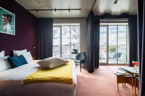 a bedroom with a bed and a desk with a chair at mk2 Hotel Paradiso Nation in Paris