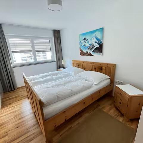 a bedroom with a wooden bed in a room at Ferienwohnung Familie Alt Rinn, Innsbruck in Rinn