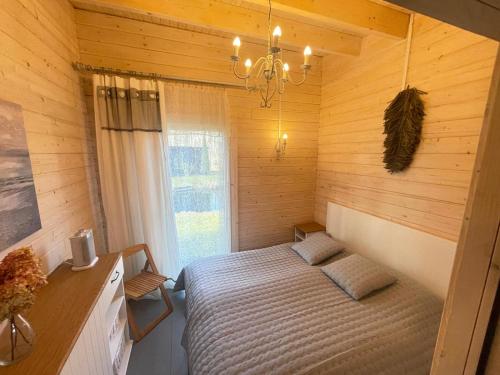 a bedroom with a bed in a wooden room at Māja pie Ziedu laivas in Plieņciems