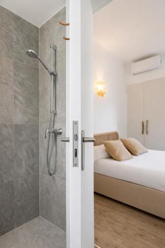 a bathroom with a shower and a bed in a room at Hôtel Almanarre Plage - Hôtel Eco-Responsable face à la mer in Hyères
