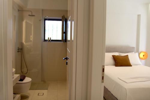 a bathroom with a bed and a toilet and a shower at SUMU Luxury Apartment in Lefkada