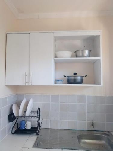 a kitchen with a sink and a cupboard with dishes at Ibus Nawi Homes 2 in Lodwar
