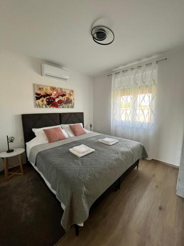 a bedroom with a large bed with two towels on it at Blackberry Guesthouse in Jastrebarsko