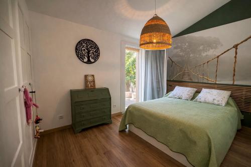 Un dormitorio con una cama verde y una ventana. en Agapi Mou, en Les Baux-de-Provence