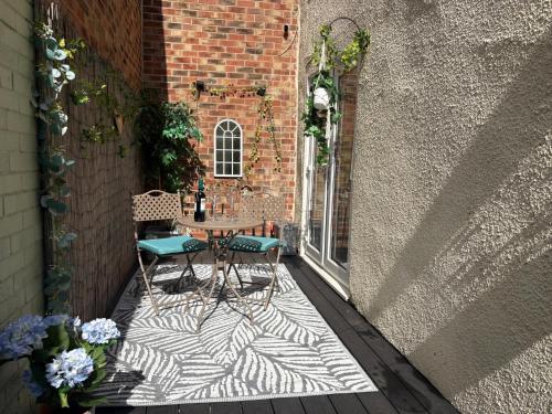a patio with two chairs and a table and a building at Silver Cottage on Yarm High street and the River free parking available in Yarm