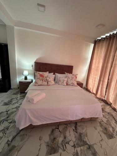 a bedroom with a large bed with pink sheets at The calm villa in Kandana