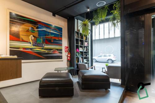 a lobby with two chairs and a painting on the wall at Hotiday Milano Risorgimento in Milan
