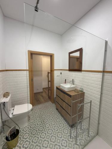 a bathroom with a sink and a toilet and a mirror at Casa & Caminho AL in Velas