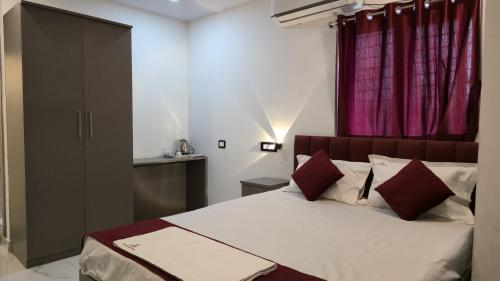 a bedroom with a large bed with red curtains at Hotel Panchvati in Durgāpur