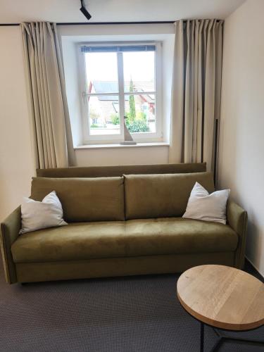 a couch in a living room with a window at Amtsstube1892 - Übernachten im alten Gefängnis in Überlingen