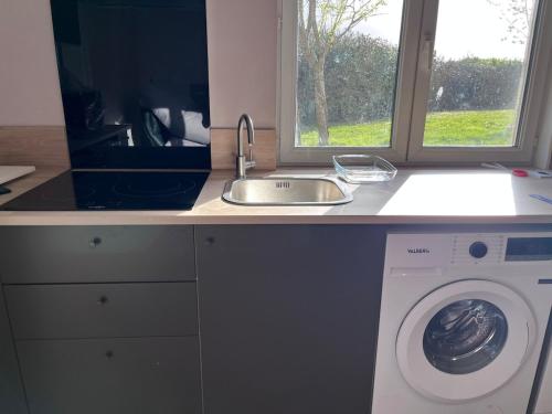 a kitchen with a sink and a washing machine at Fully equipped, independent apartment in Marles-en-Brie