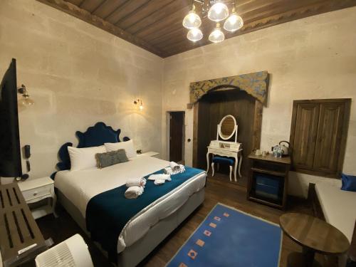 a bedroom with a bed and a table with a mirror at Sevdalı Konakları in Avanos