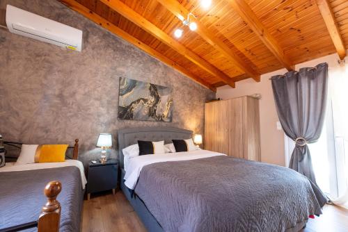 a bedroom with two beds and a wooden ceiling at Dream Houses Near Athens Airport By SEM in Artemida