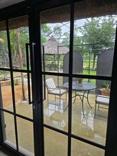 a view of a table and chairs through a window at The House On The Hill in Lanseria