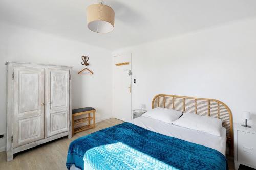 a bedroom with a bed with a blue blanket at Les Passiflores - Chambre d'Hôtes in Pornic