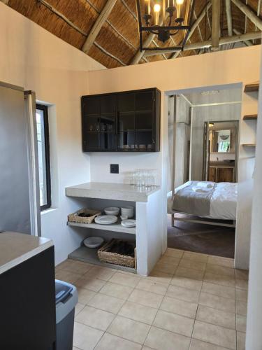 a bedroom with a bed and a bathroom with a counter at The House On The Hill in Lanseria