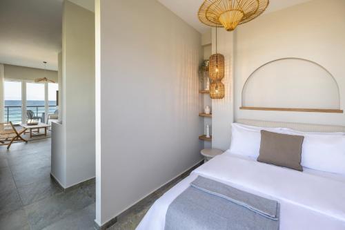 a bedroom with a bed and a view of the ocean at Cavo Dio 7 - Beachfront bliss - Cozy Apt Pool Sunset in Káto Dhiminión