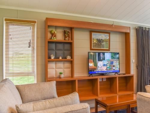 a living room with a tv on a wooden entertainment center at Whitey Top Country Lodge in Pentridge