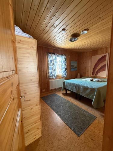a bedroom with a bed in a wooden room at Rauhan pesä in Karigasniemi